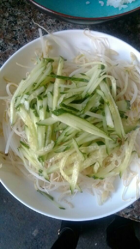 蒜泥白肉,铺在盘底，黄瓜丝放在豆芽上面