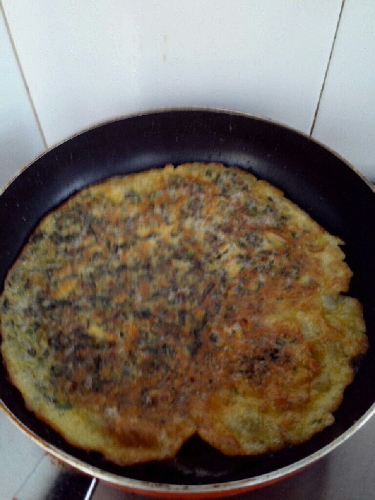 香椿摊鸡蛋,平底锅放少许油烧热,把香椿蛋液到锅里,摊平,中火慢慢煎一面熟了再反另一面煎,煎一会就好啦,放盘里就可以吃了,简单吧,而且还有营养。