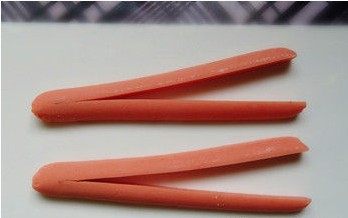 爱心火腿煎蛋,切好的火腿肠 ，平面向下， 弧面向上，再从中间一分为二 尾端留住一厘米不切开