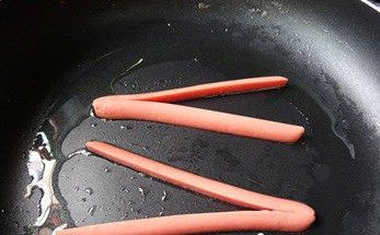 爱心火腿煎蛋,平底锅加一勺油 ，将油抹匀，将火腿放进平底锅 开小火