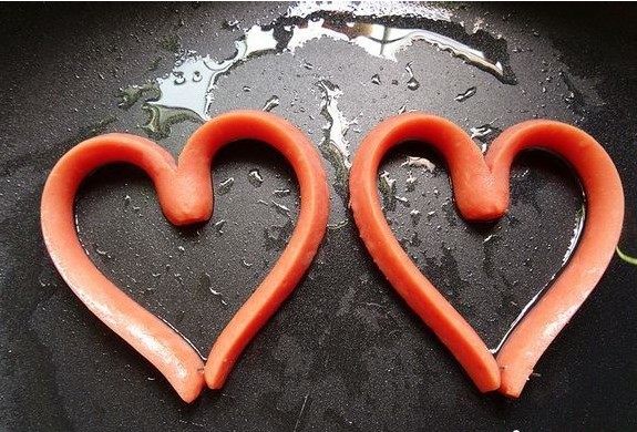 爱心火腿煎蛋,待锅热 ，火腿热后，火腿变软 ，这时将火腿的两端慢慢的弯过来，用牙签，形成心的形状