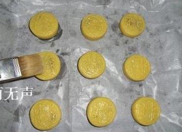 杏仁蜜桃酥,放入垫了烤纸的烤盘,用饼干圈全部按扁成圆柱体,表面刷上少量清水