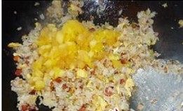 什锦菠萝炒饭,最后倒入炒好的鸡蛋和菠萝丁，翻炒均匀， 将炒好的米饭装入菠萝容器中