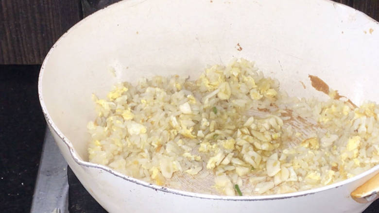 酸豇豆蛋炒饭,打开锅盖炒匀,加入蒜炒香,再一起炒匀
