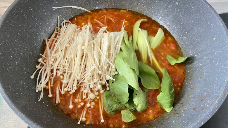 酸汤肉片,加入金针菇青菜,煮开加盖小火炖煮一分钟