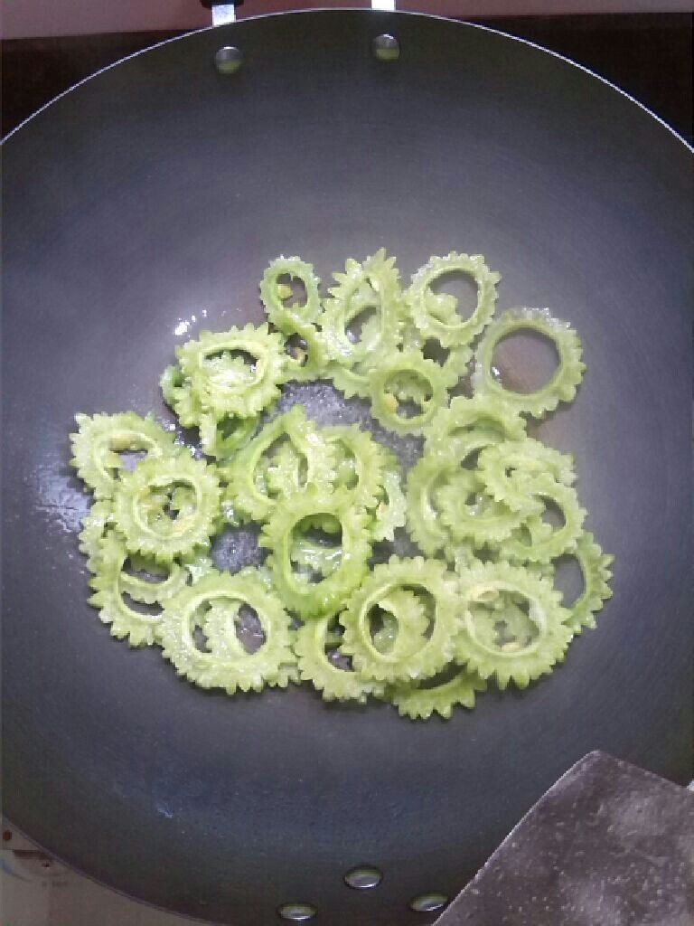   苦瓜炒蛋,   开火将油倒入，   苦瓜下锅炒软，
