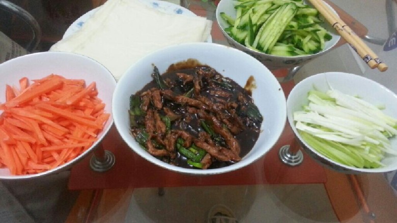 京酱肉丝包饼,最后，根据个人口味把材料包进春卷皮就行。