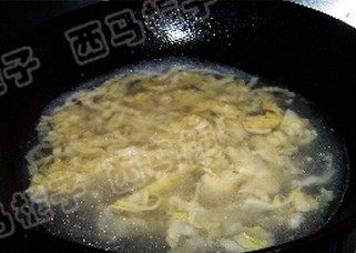 酸菜白肉火锅,下入酸菜丝煸炒均匀，倒入煮肉的原汤烧开。