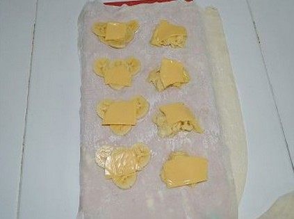 酥炸爱心水果馄饨,将备好的香蕉、榴莲肉分别放在心形的中间,撒上适量的白糖