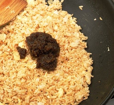 沙茶牛肉炒饭,将剩余的鸡蛋利用锅中余下的油滑散,加入腌制过的冷饭,炒热以后再加入1勺沙茶酱