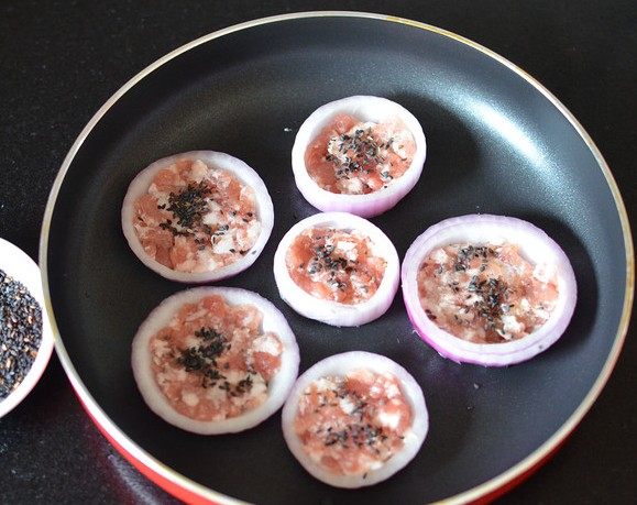 洋葱鲜肉饼,在平底锅中将肉馅放在洋葱圈里，撒上少许<a style='color:red;display:inline-block;' href='/shicai/ 666'>芝麻</a>。