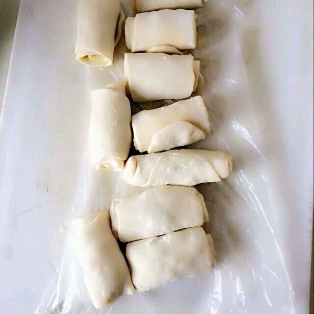葱油饼,不粘锅内倒一点点油,开小火,取一个卷好的面团,竖着放入锅里。用手扶着防止倒下,约10秒钟后,用平底的金属质地的东西,将面团从上往下压,反复压5-7次,每压一次翻个面,一直压到扁平,每个都这样。