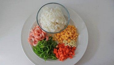 虾仁芝士焗饭,虾仁解冻后冲洗控水,尖椒切丝,胡萝卜切丁,蒜瓣切片。