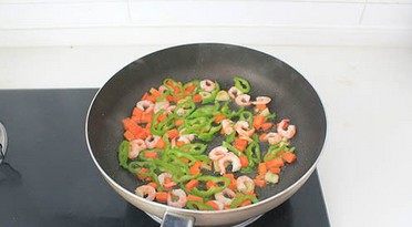 虾仁芝士焗饭,放虾仁和尖椒丝,调入1勺盐翻炒均匀至虾仁变色、熟透。