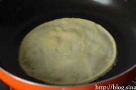 水果千层蛋糕,将冷藏后的面糊舀入锅中,用手举着锅子晃开面糊,摊开