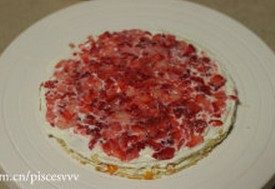 水果千层蛋糕,盖上饼皮,抹上奶油,放上草莓,如此一层一层循环,直至放完所有的饼皮