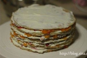 水果千层蛋糕,用奶油将蛋糕顶部及四周略抹平,表面盖上一片饼皮