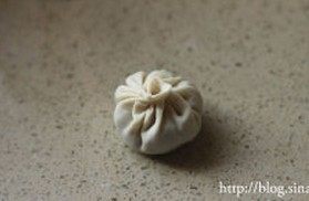 灌汤小笼包,包入适量的肉馅,用手沿同一方向打褶,将包子包好