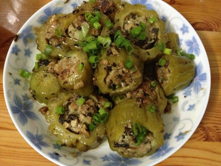 客家酿苦瓜,放适量油，待火候一到，将酿苦瓜放入油锅，十五分钟双面煎熟，最后生粉与豆豉相拌勾芡撒点葱花出锅！