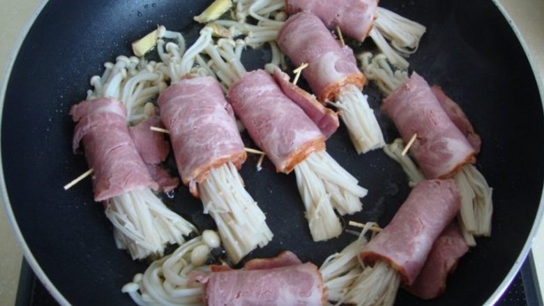 金针菇培根卷,橄榄油炒香<a style='color:red;display:inline-block;' href='/shicai/ 37'>姜</a>，放入培根卷煎黄