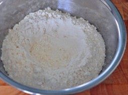 培根土豆披萨,高筋面粉和盐混合后放进大碗,中间开穴,四周撒上酵母粉