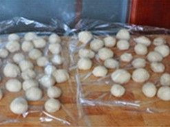 猴子面包,取出面团排气后,分割成若干大小不一的小面团,滚圆,盖上保鲜膜松弛15分钟