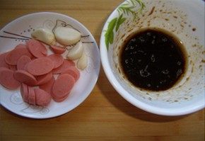 火腿煲仔饭,火腿切片,将老抽约半勺、生抽1勺、耗油1勺、香油几滴、白糖半勺混合成调味汁待用