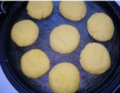 手撕鲅鱼黄金饼,电饼铛刷油，将玉米面团成小饼，煎至一面焦黄成熟