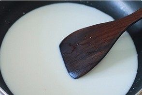 脆皮炸鲜奶,牛奶中加入白糖,炼乳,淀粉搅拌均匀,倒入锅中,小火加热