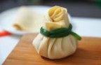 韭腐包,把馅铺在腐皮中间,加一勺高汤进去,卷起来,用韭菜包扎好