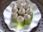 鲜虾酿丝瓜,将虾胶填在丝瓜礅里，插入虾尾巴整理光滑，入锅中大火蒸6至8分钟