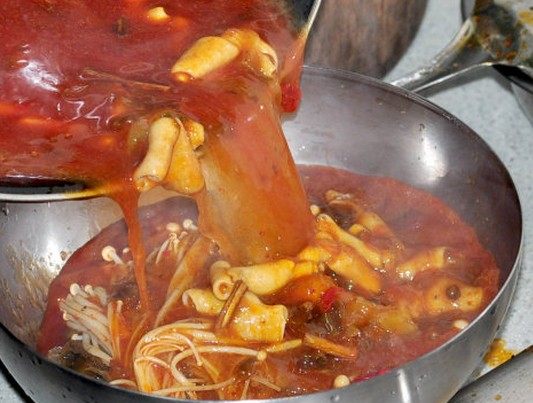金针冒鹅肠,滚开的汤料中下入鹅肠,鹅肠下锅以后用大火快速烧开