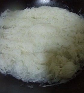 XO酱炒萝卜糕,把萝卜丝放入炒锅内,炒至变软