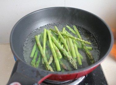 响油芦笋,水开后放入芦笋焯1分钟左右，芦笋颜色变深绿色即可，捞出立刻浸入冷水。