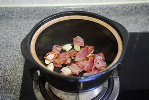 培根茄子煲,煎好的培根和大蒜移入砂煲