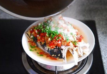 剁椒鱼头,取出盘子，洒<a style='color:red;display:inline-block;' href='/shicai/ 3250'>葱</a>花和蒜碎，茶油烧至冒烟浇在鱼头上即成