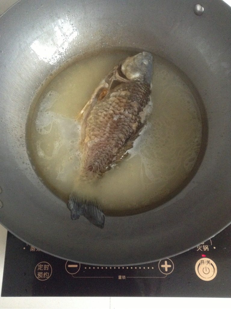 鲫鱼豆腐汤,然后均匀的淋在已煎好的鱼身上。再放两碗水,直到快淹没鱼身。