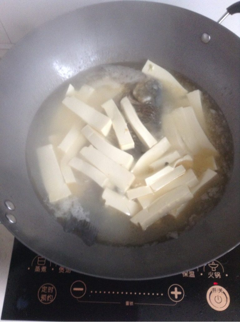 鲫鱼豆腐汤,鱼汤烧的差不多开时,放入切好的豆腐。然后在洒少许盐,淋一点醋在鱼身上,放点鸡精,用锅铲轻轻的炒动一下。