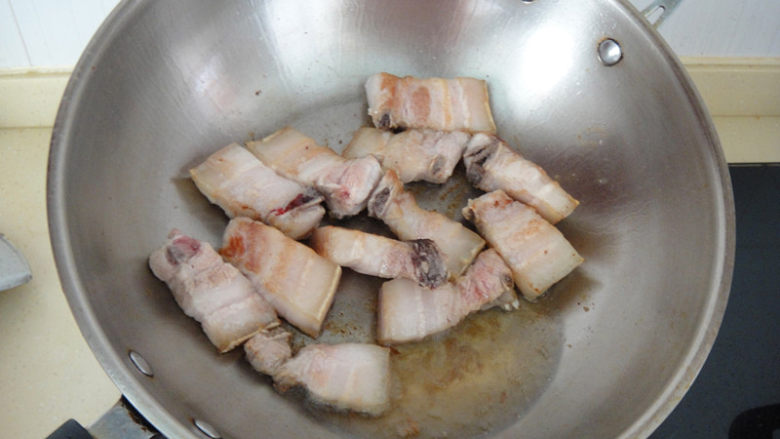 上海红烧肉,热锅加入底油,放入五花肉,把肉两面煎至变色后倒出多余的油