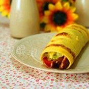 鸡肉卷,鸡蛋饼平铺在盘子上,放入适量的生菜丝、鸡肉和圣女果,卷起翻面放置即可