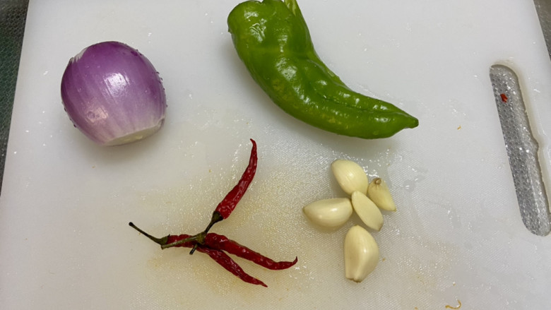 椒盐日本豆腐,准备配菜：洋葱剥去外皮洗净，青椒去蒂去籽洗净，小米辣洗净，蒜剥皮