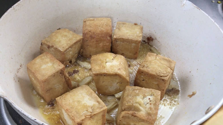 煎酿豆腐,煎至全面金黄,加入姜炒香