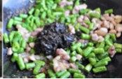 榄菜肉丁四季豆,下蒜末和肉丁翻炒,至肉丁炒熟有轻微焦黄色后,放入四季豆及榄菜一同翻炒均匀,调味出锅