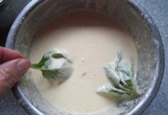 香炸薄荷,提着薄荷的茎将叶子部分放入面糊里沾匀,使叶片全部粘上面糊
