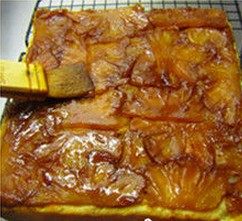 糖菠萝翻转蛋糕,出炉立即倒扣从硅胶模里取出晾网上晾凉,将滤出的焦糖菠萝汁刷一些到菠萝片上就可以了