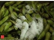 茶香毛豆,用剪刀将豆荚剪下,加入1汤匙盐