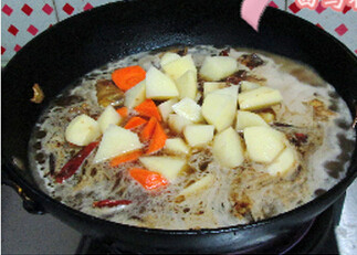 大盘鸡,加入热水，大火烧开，加入土豆和胡萝卜块