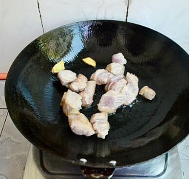 干豆角香焖五花肉,锅内放入一点点的油,烧热,加入姜片爆香,再放入五花肉爆至微金黄