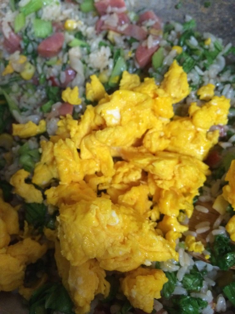 什锦炒饭,如图待调味料完全融入菜、饭的時候，青菜也基本上熟了，再倒入鸡蛋翻炒几下就大功告成了；