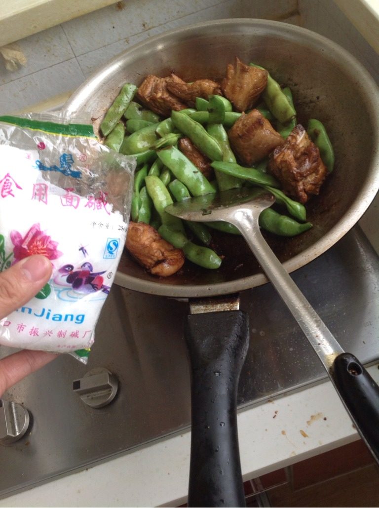 排骨炖豆角,如图放入半勺面碱，可让豆角保持翠绿且易熟（窍门哦！）